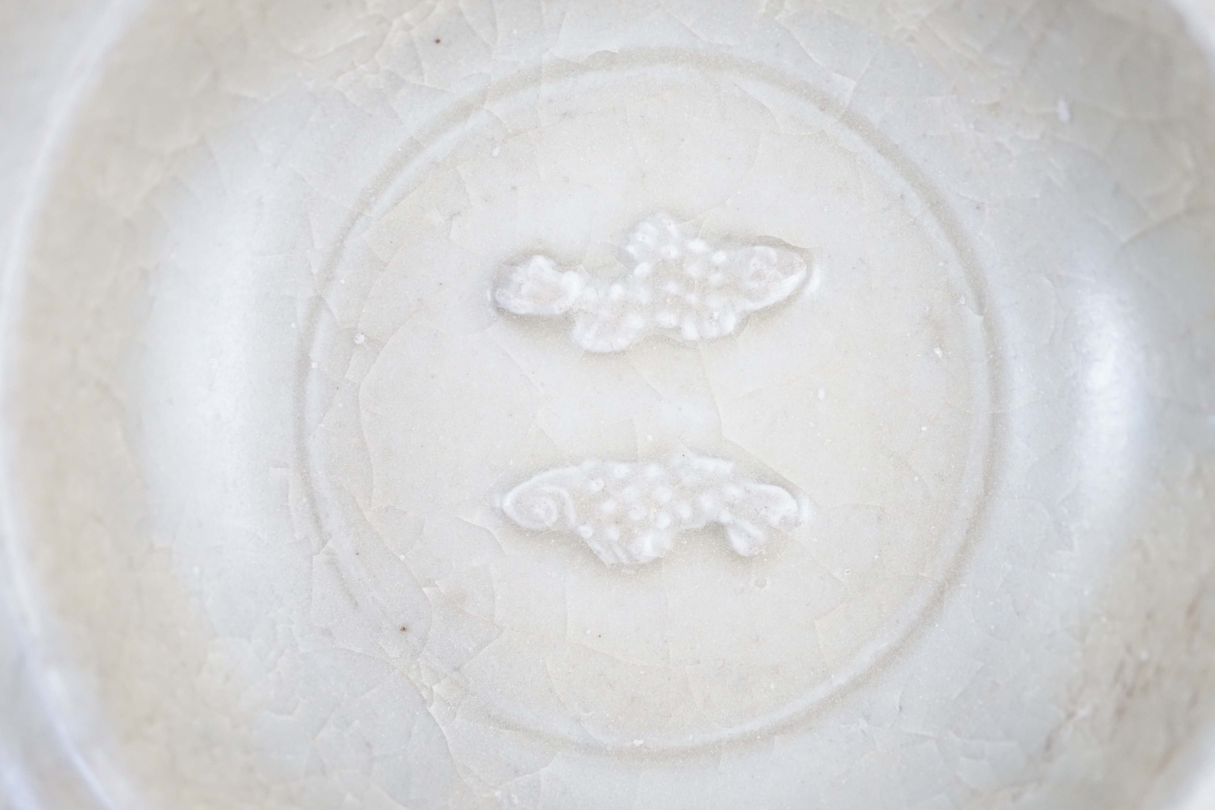 A small Chinese Longquan ‘golden’ celadon ‘twin-fish’ marriage dish, Southern Song-Yuan dynasty, 12cm diameter